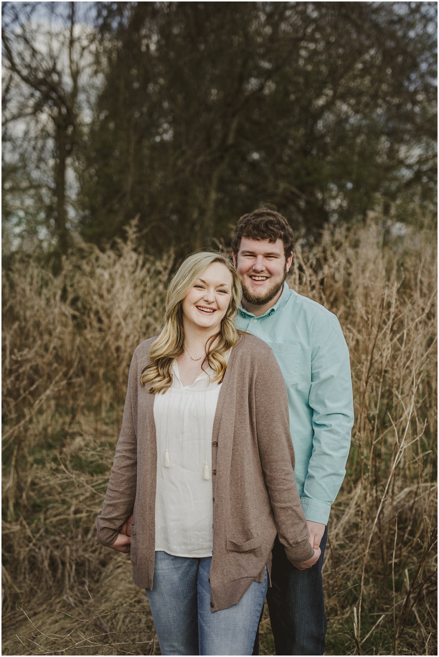 A vertical portrait of Emily and Nathan at Meadow Hill Farm with the tall grass as a backdrop.