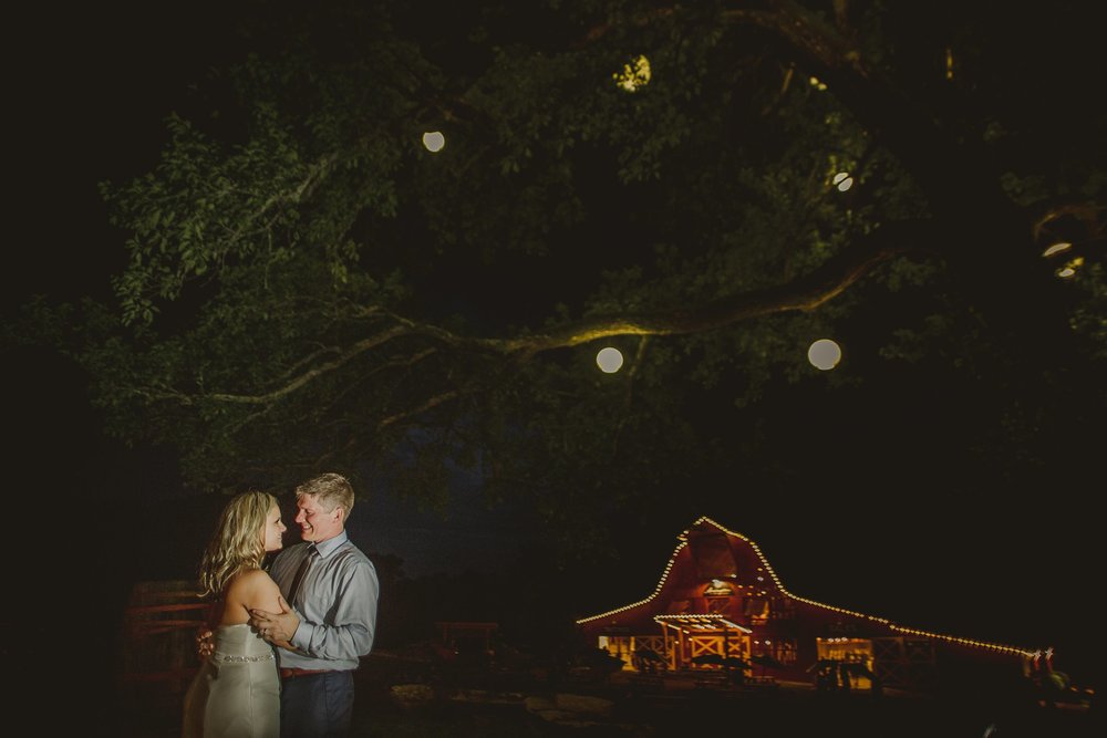 bride and groom under the big oak tree at night time