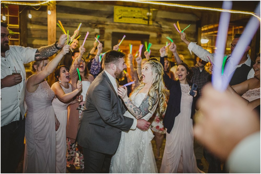 Bride and groom exit with glow sticks at Evins Mill Wedding.