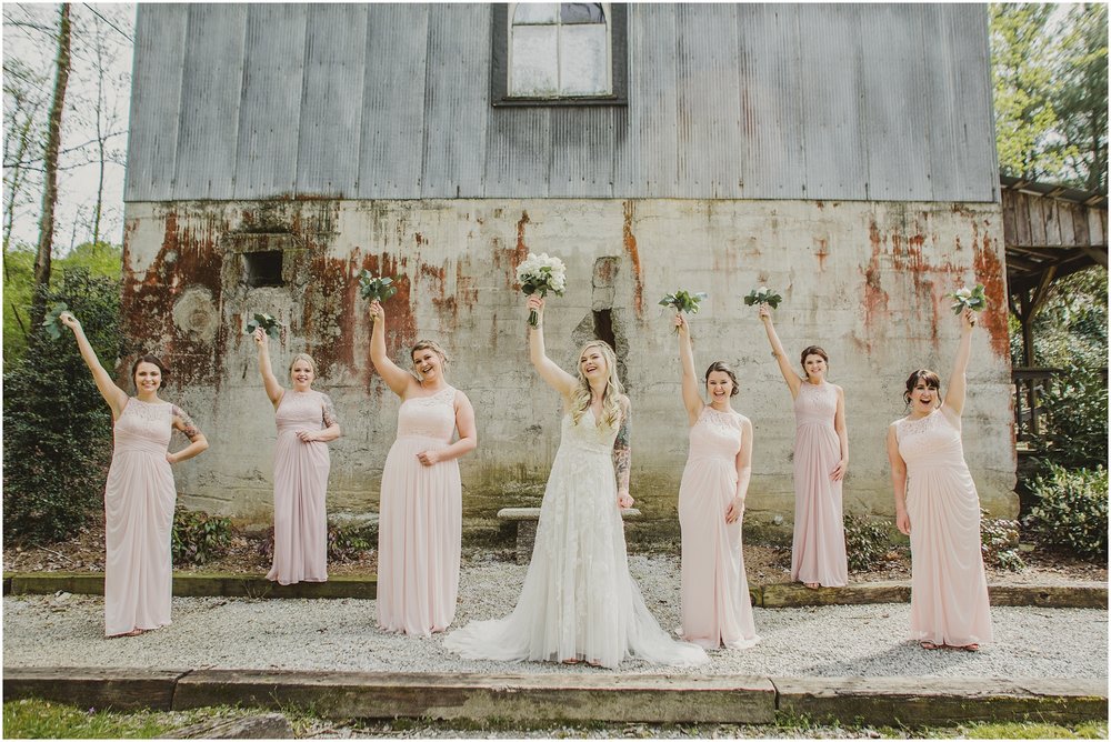 Bridesmaids hold their flowers up above them as they get excited for the wedding.