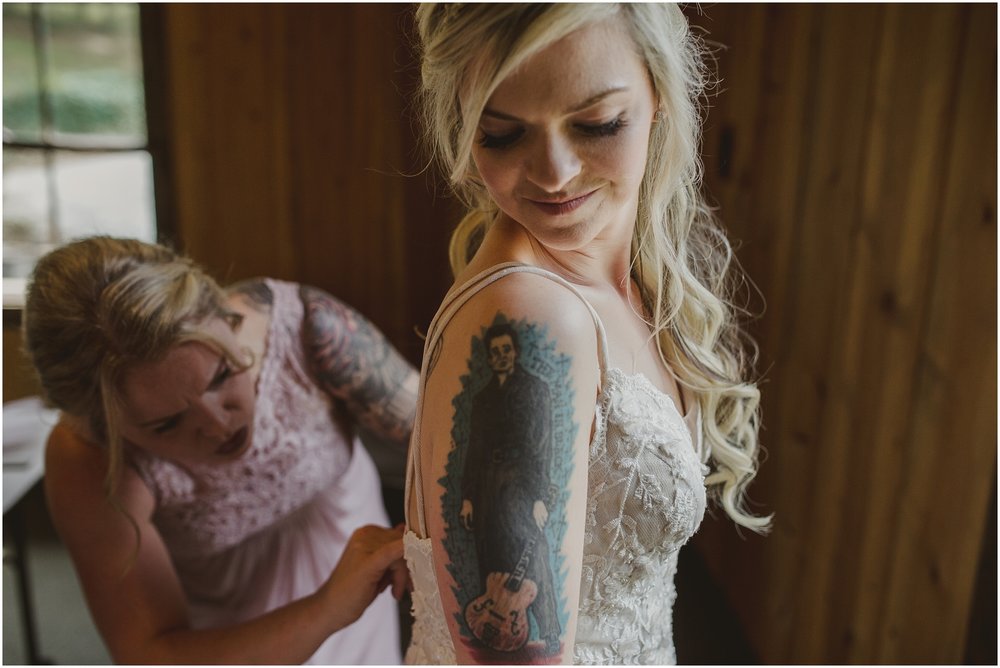 The bridesmaids zip bride into her gown at the Evins Mill Wedding Venue.