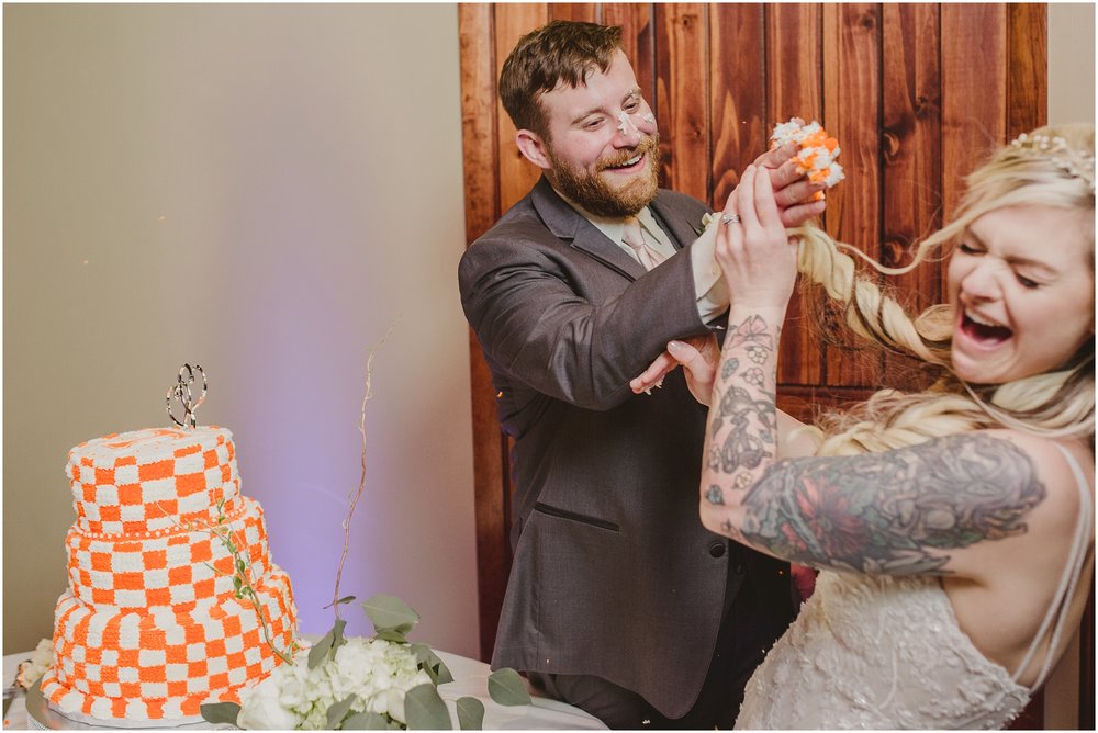 The groom smashes cake into the bride's face at Evins Mill Wedding.