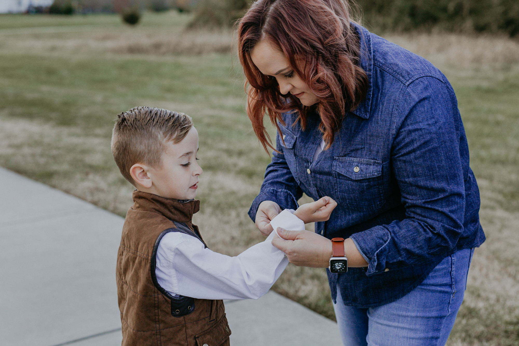 Mom fixes her sons shirt during spring hill family photos.