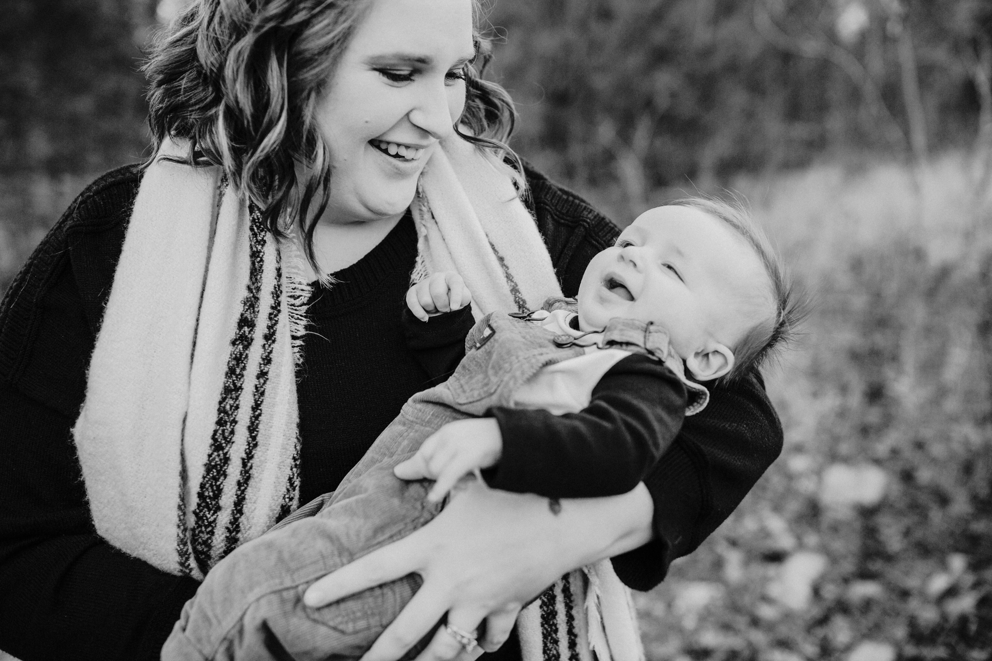 Mom holds baby boy while looking at him in her arms during their family session in chapel hill.
