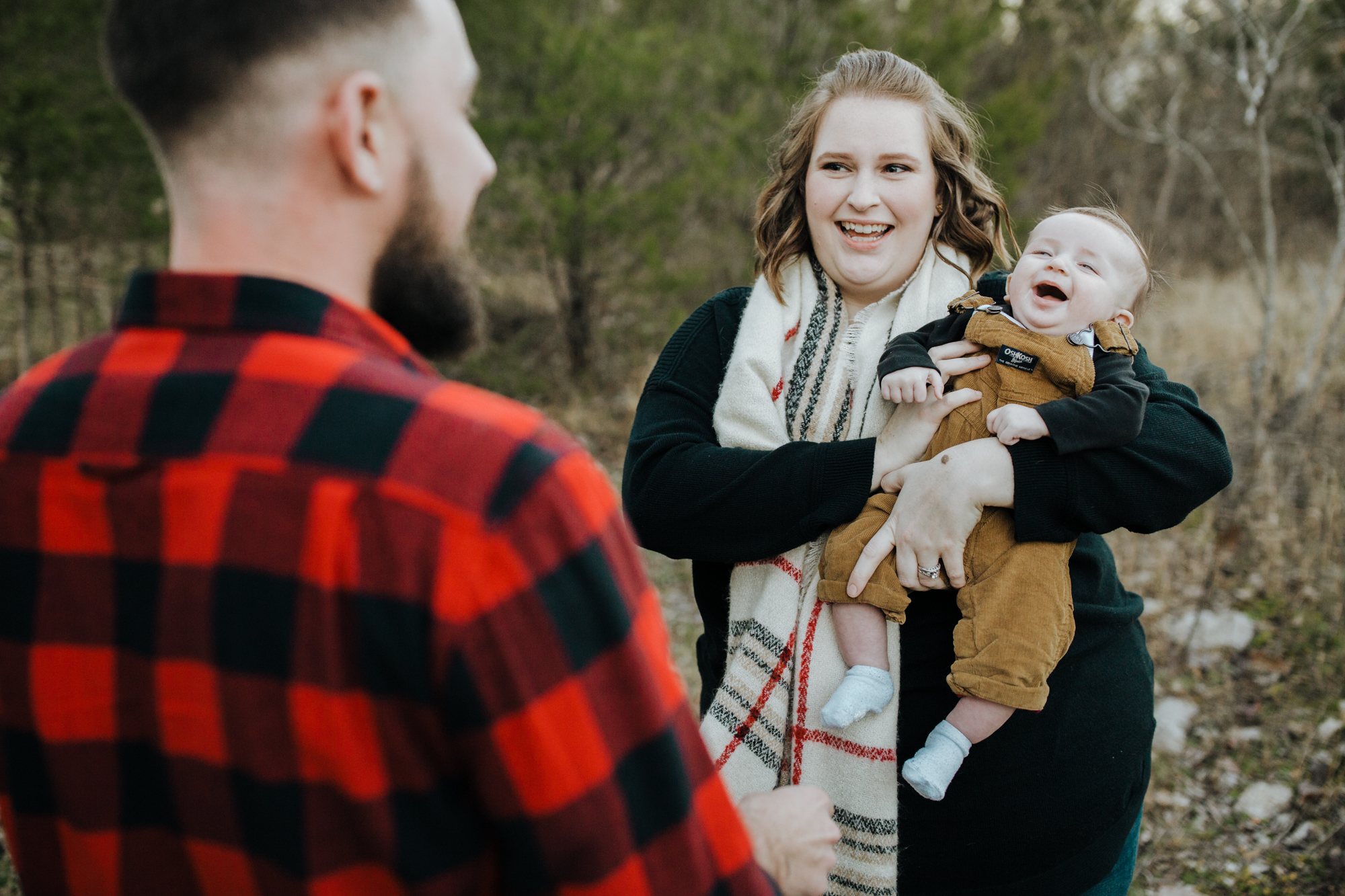 Mom holds baby while dad makes baby laugh during their family session in chapel hill.