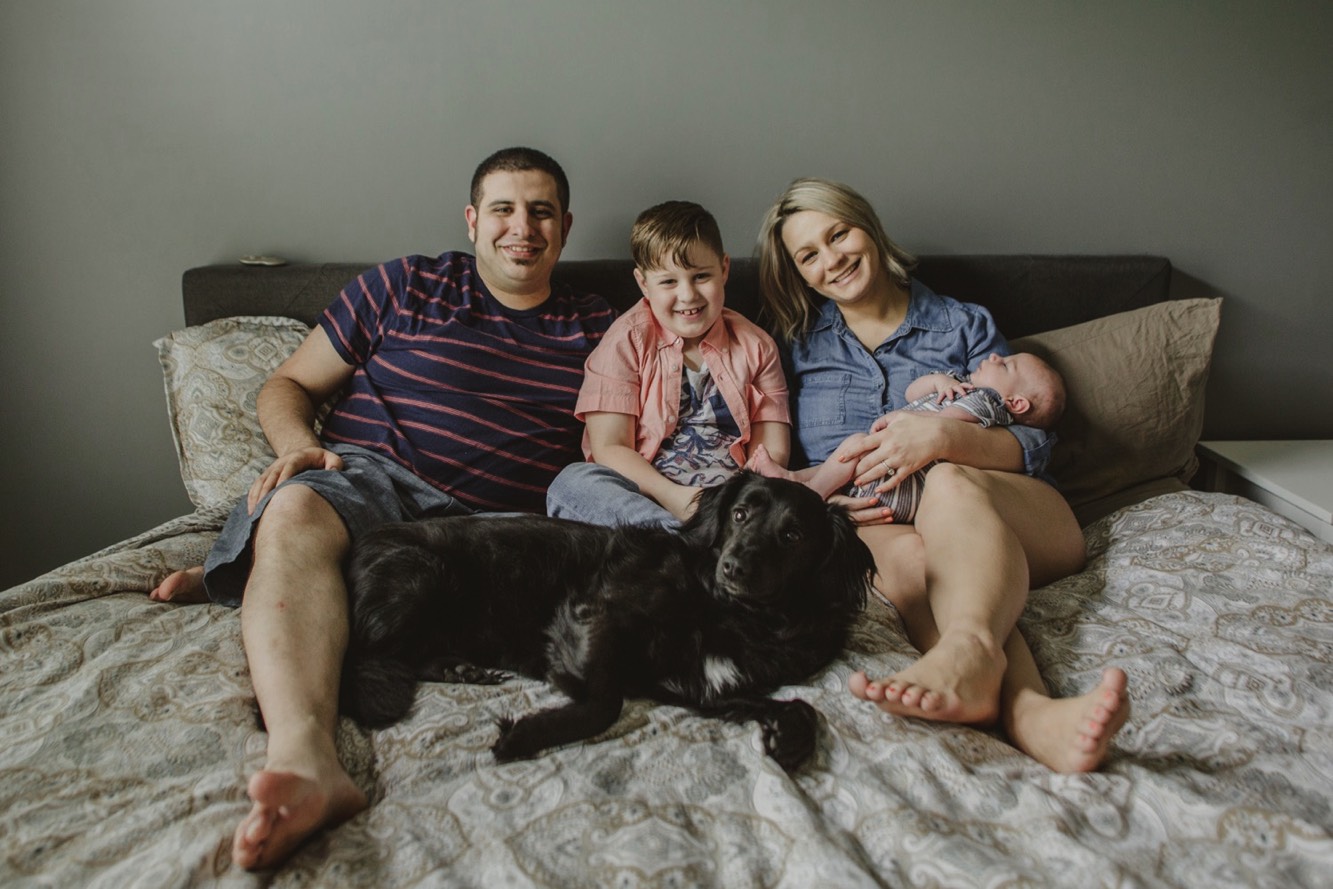 During the newborn session in Spring Hill, Tennessee the family dog gets on the bed.