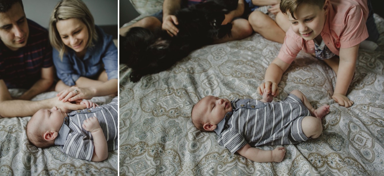 Family stares at baby boy while he lays on the bed during newborn session.