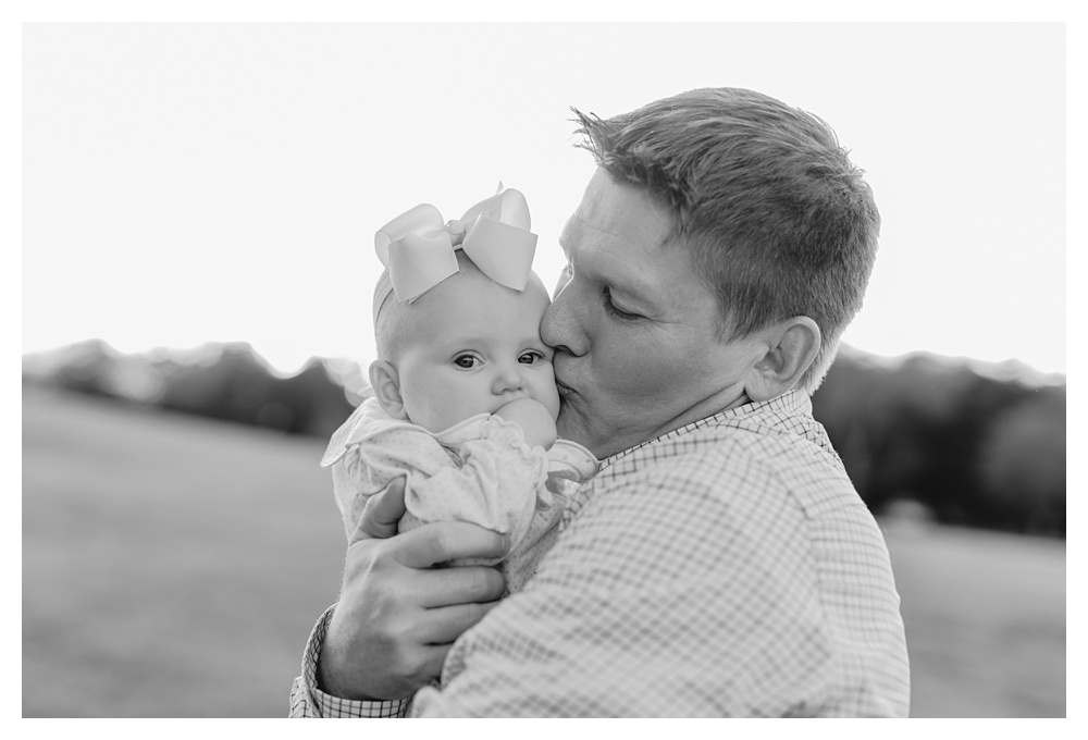 dad kissing baby girl on cheek at Arrington Vineyard Family Portraits