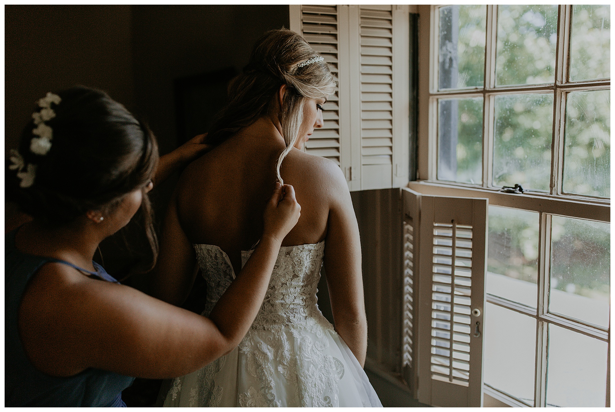Lauren's sister helps Lauren zip her wedding dress up at the Cool Springs House.