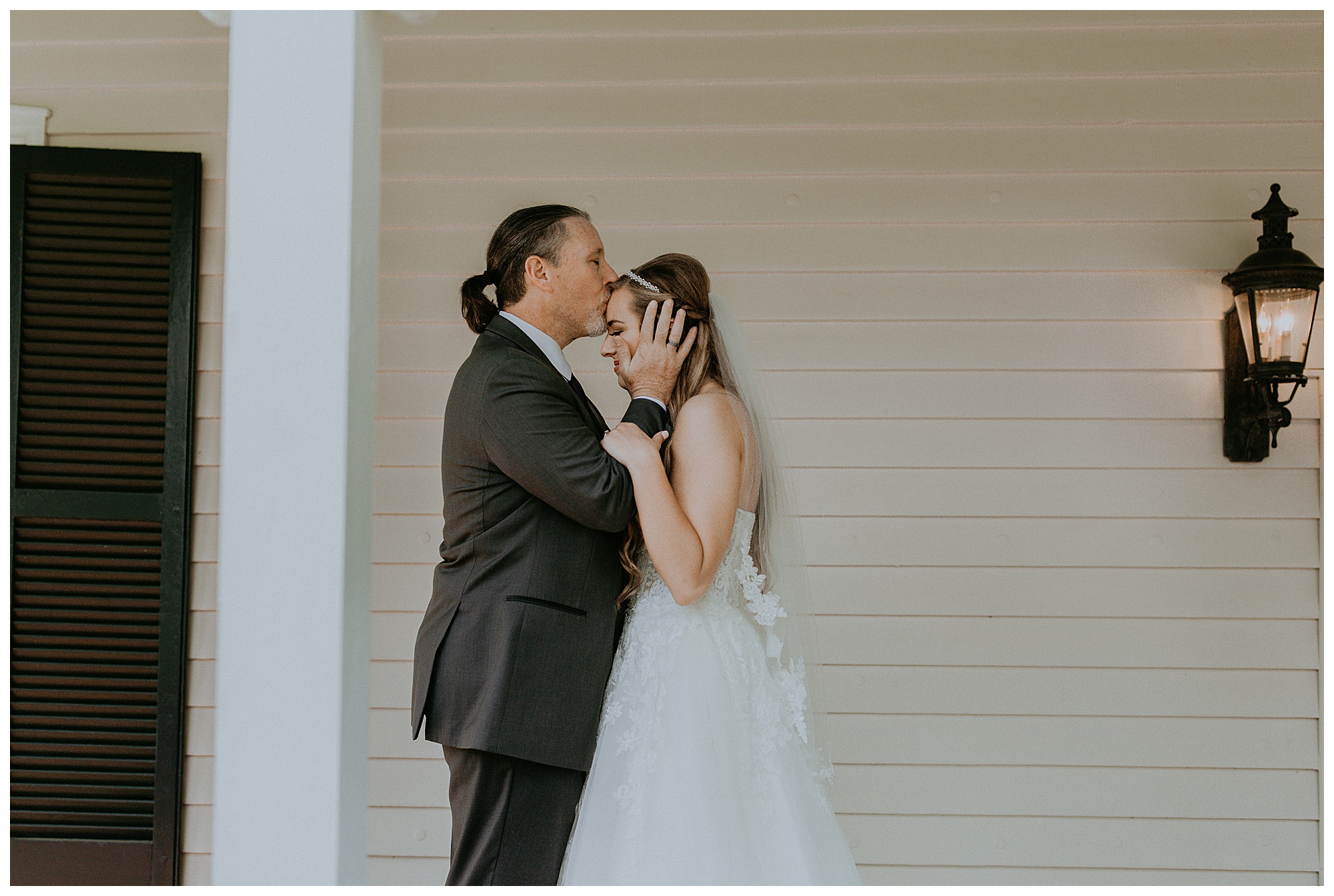 father of the bride kisses his daughter's forehead after their first look at the Cool Springs House.