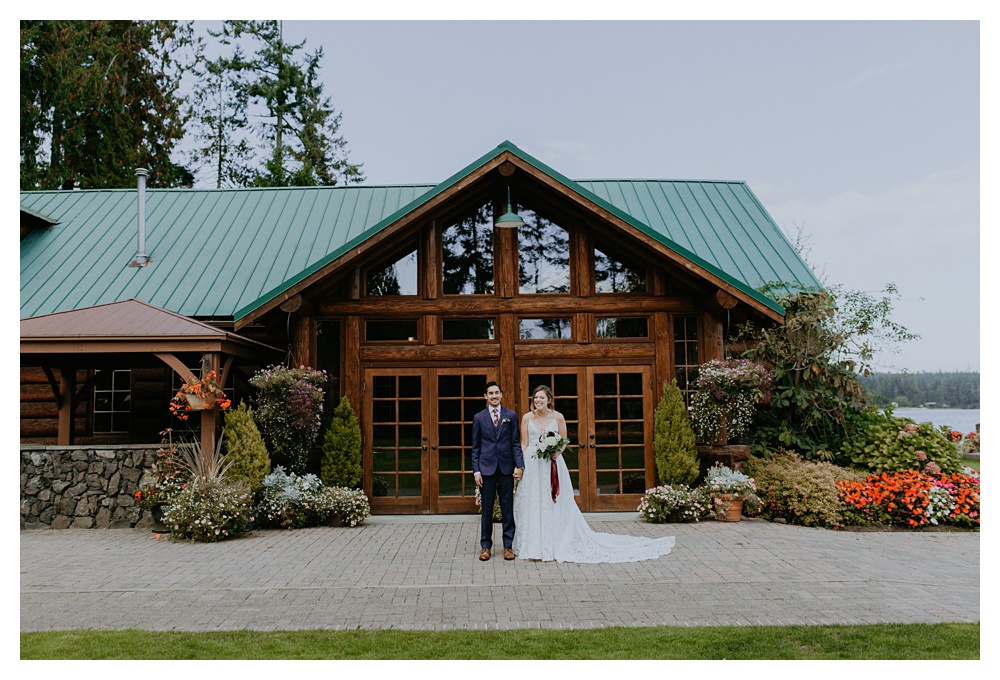 the bride and groom pose in front of Kiana Lodge in Washington State.