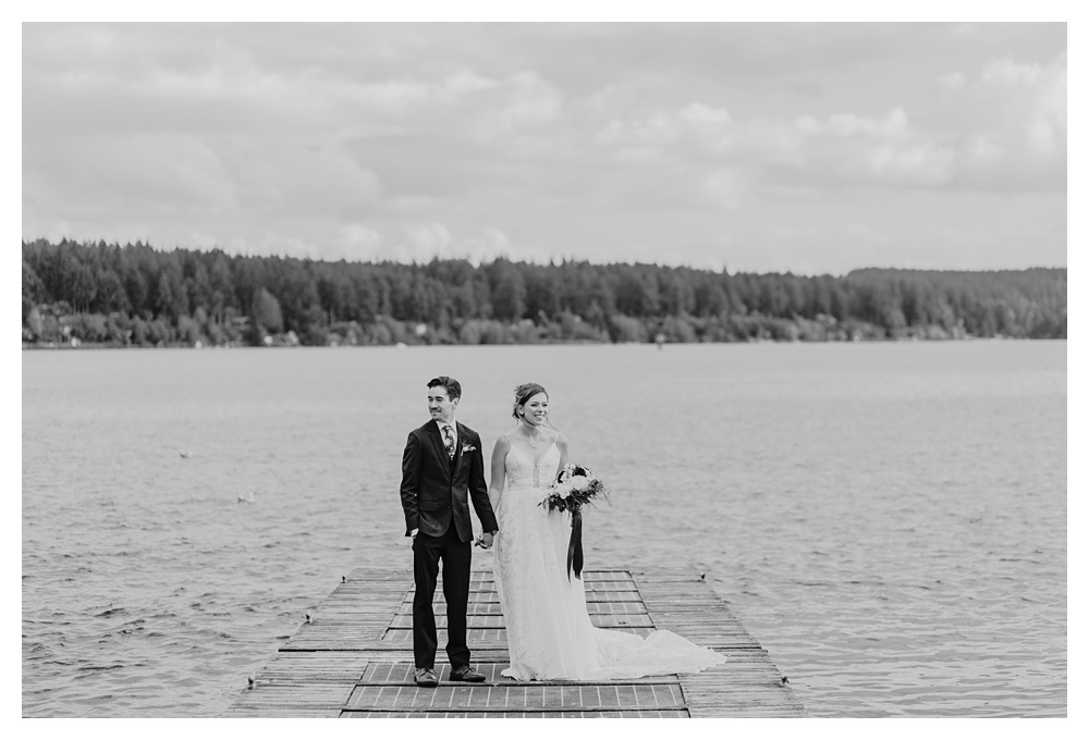 a black and white photo of the bride and groom out on the dock at Kiana Lodge in Washington State.