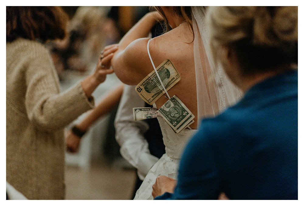 Guests putting dollar bills on the couple during the dollar dance at Kiana Lodge.