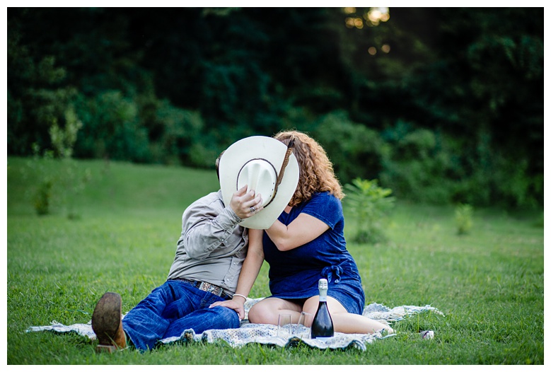 cowboy kisses cowgirl behind his hat, nashville engagement, nashville engagement photographer, Spring Hill Tennessee, outdoor engagement photos, field engagement photos, cowboy hat, cowboy, western engagement photos, Spring Hill engagement photographer, cowboy and cowgirl, summer engagement photos