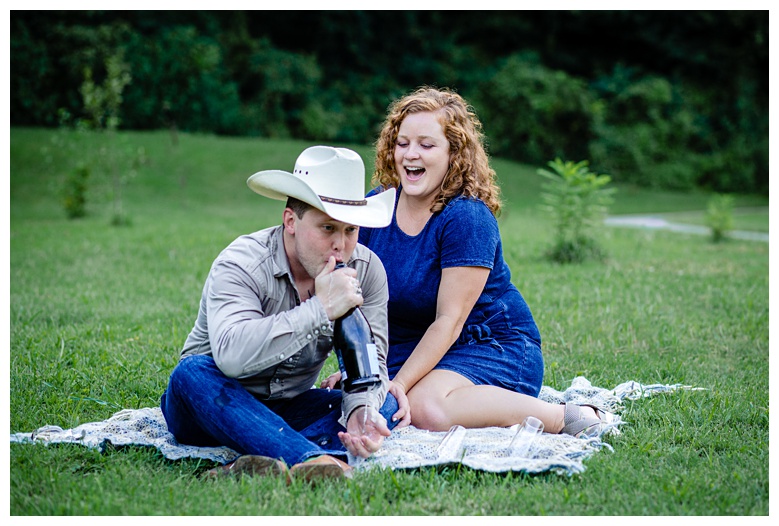 cowboy drinks from champagne bottle, nashville engagement, nashville engagement photographer, Spring Hill Tennessee, outdoor engagement photos, field engagement photos, cowboy hat, cowboy, western engagement photos, Spring Hill engagement photographer, cowboy and cowgirl, summer engagement photos