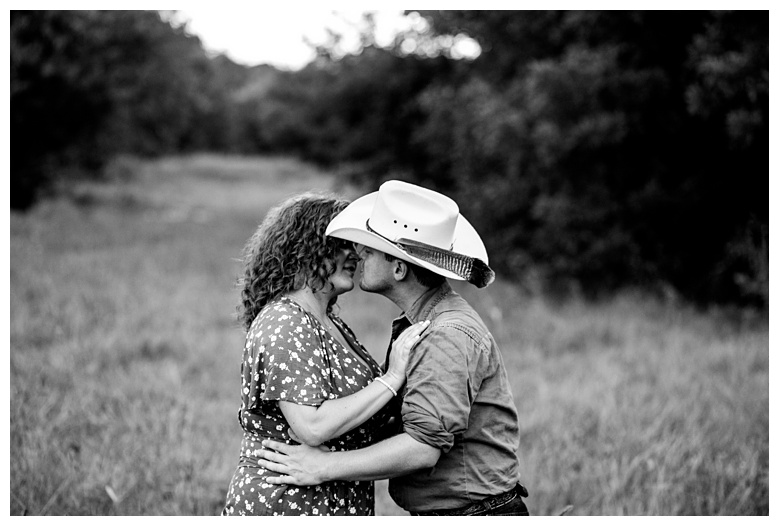 cowboy and fiancé kiss in a field, nashville engagement, nashville engagement photographer, Spring Hill Tennessee, outdoor engagement photos, field engagement photos, cowboy hat, cowboy, western engagement photos, Spring Hill engagement photographer, cowboy and cowgirl, summer engagement photos