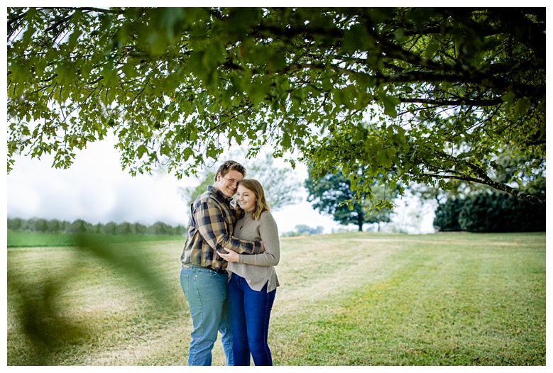 engaged couple snuggle under oak tree, nashville engagement, nashville engagement photographer, Columbia Tennessee, outdoor engagement photos, Spring Hill engagement photographer, summer engagement photos, mule town Tennessee, columbia tn mural