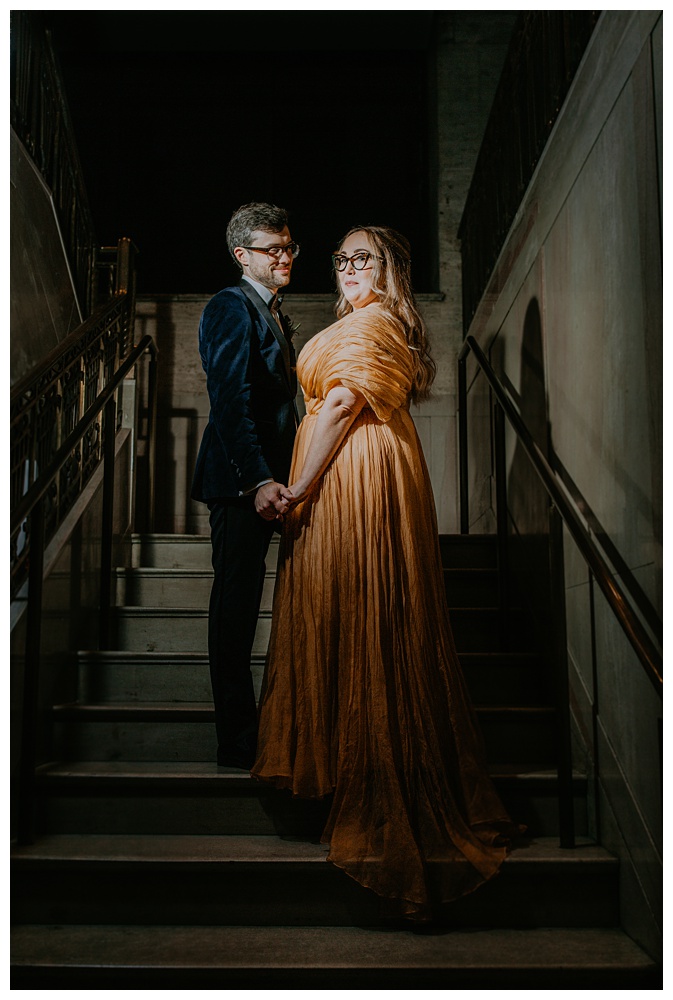 Bride and Groom pose on grand staircase at Noelle Hotel in Downtown Nashville, Boutique Luxury Downtown Nashville Hotel, Nashville Wedding Photographer, Nashville Photographer, Downtown Nashville hotel, modern Nashville hotel, Nashville Intimate Wedding, Nashville Micro wedding, Nashville Photographer, Nashville get-a-way, Non-traditional wedding dress, velvet tuxedo, non-traditional wedding, gold wedding dress