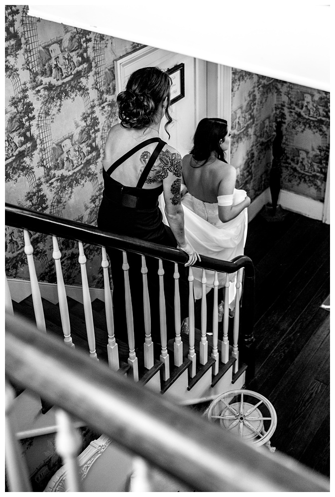 the bride walking down stairs with a bridesmaid holding up her train, nashville wedding photographer, nashville wedding, nashville Tennessee wedding, intimate wedding, Drakewood Farm, intimate nashville wedding, intimate outdoor wedding, intimate backyard wedding, intimate elopement, Tennessee elopement