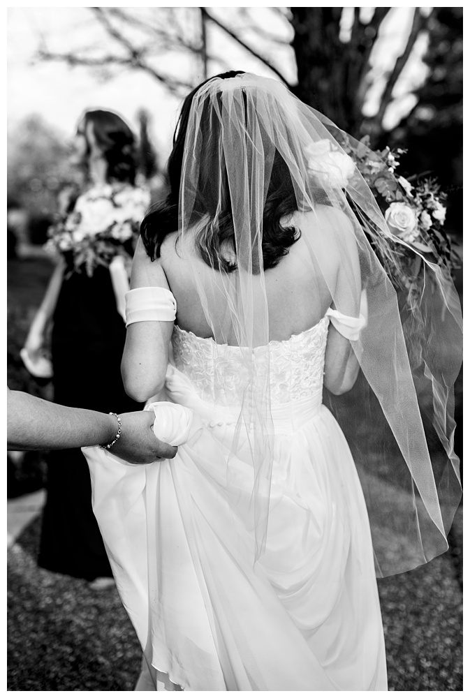the bride walking while a bridesmaid holds her dress up, nashville wedding photographer, nashville wedding, nashville Tennessee wedding, intimate wedding, Drakewood Farm, intimate nashville wedding, intimate outdoor wedding, intimate backyard wedding, intimate elopement, Tennessee elopement