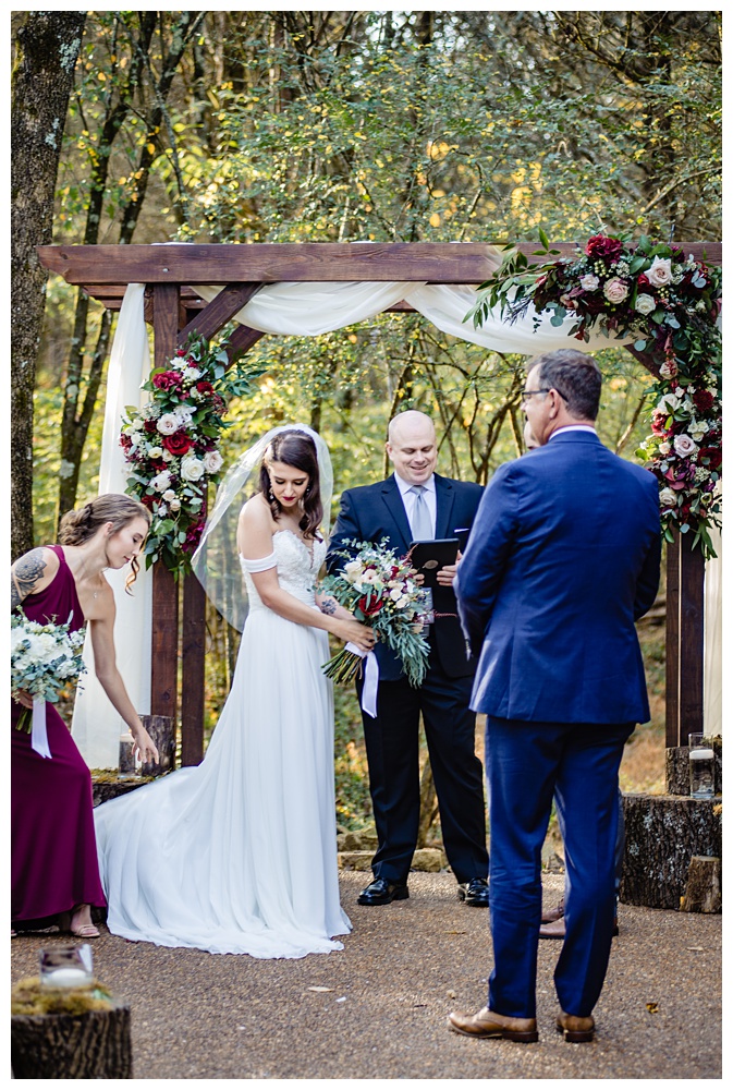 the bride stands up front with her dad as her maid of honor straightens her dress, nashville wedding photographer, nashville wedding, nashville Tennessee wedding, intimate wedding, Drakewood Farm, intimate nashville wedding, intimate outdoor wedding, intimate backyard wedding, intimate elopement, Tennessee elopement