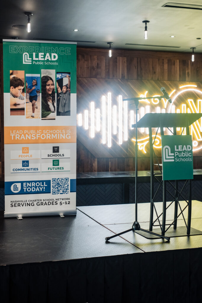 a photo of the speaker stand and tall lead public school backdrop.