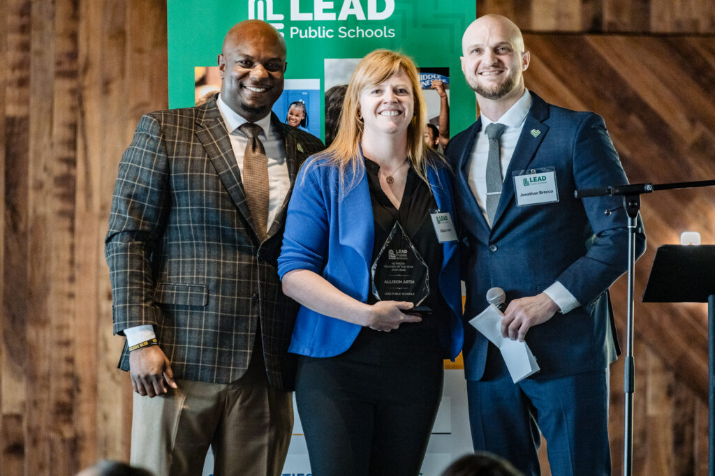Lead Public School principal and CEO with teach who received award posing at podium.